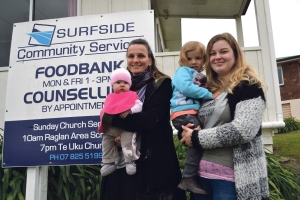 Sandra with baby Freia, left, and two-year-old Marnie held by au pair Soraja outside the foodbank from where the produce is distributed.